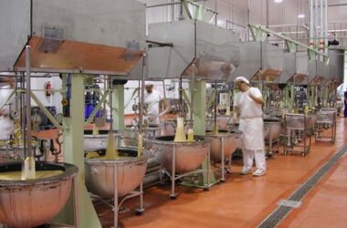 Operario en pleno proceso de cocción y mezcla del dulce navideño en los 'boixets' mecánicos de una factoría en Jijona (Alicante). Firma: Museo del Turrón