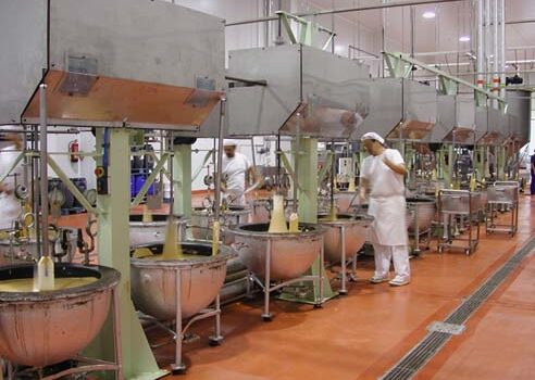 Operario en pleno proceso de cocción y mezcla del dulce navideño en los 'boixets' mecánicos de una factoría en Jijona (Alicante). Firma: Museo del Turrón