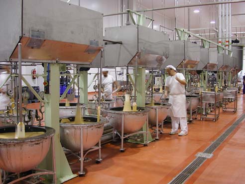 Operario en pleno proceso de cocción y mezcla del dulce navideño en los 'boixets' mecánicos de una factoría en Jijona (Alicante). Firma: Museo del Turrón
