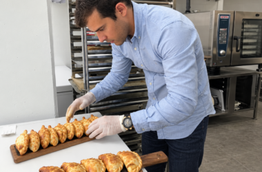 Un empleado colocando las empanadas recién horneadas en las tablas de presentación en uno de los establecimientos comerciales de Malvón. Firma: Malvón