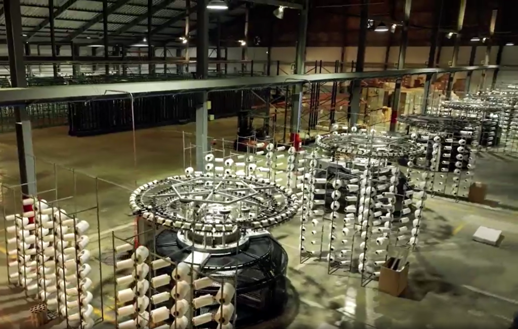 Maquinaria de tejeduría circular en la planta centroamericana de Nextil en Fraijanes (Guatemala) para la producción masiva de punto elástico. Firma: Nextil